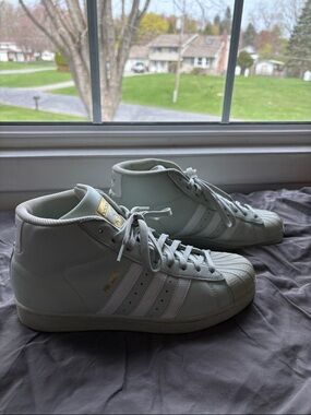 Adidas Originals Pro Model sneakers in a mint green, white, and gold colorway.